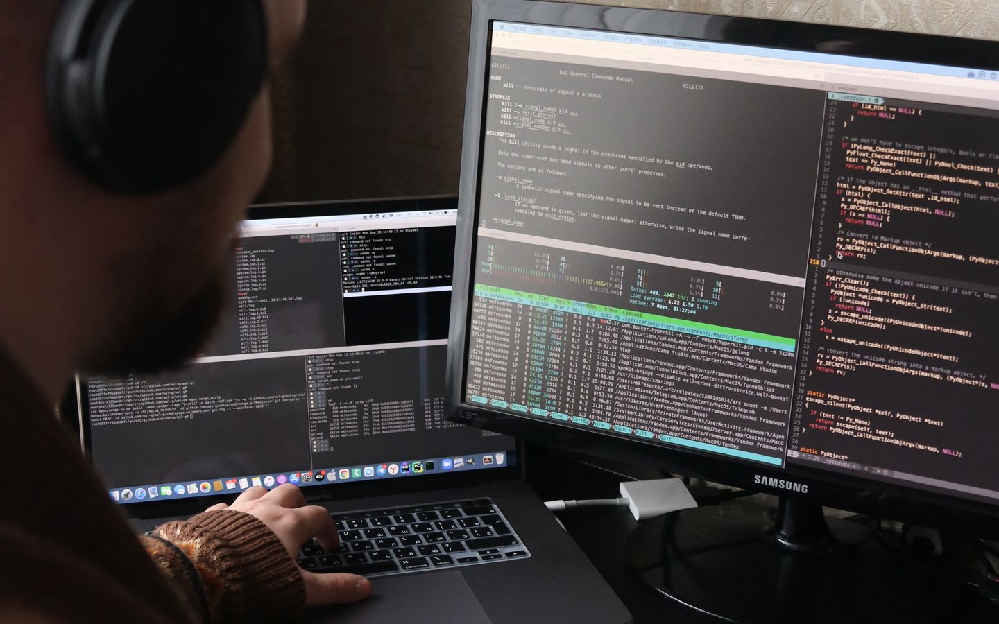 Pengembang bekerja menggunakan laptop dan monitor